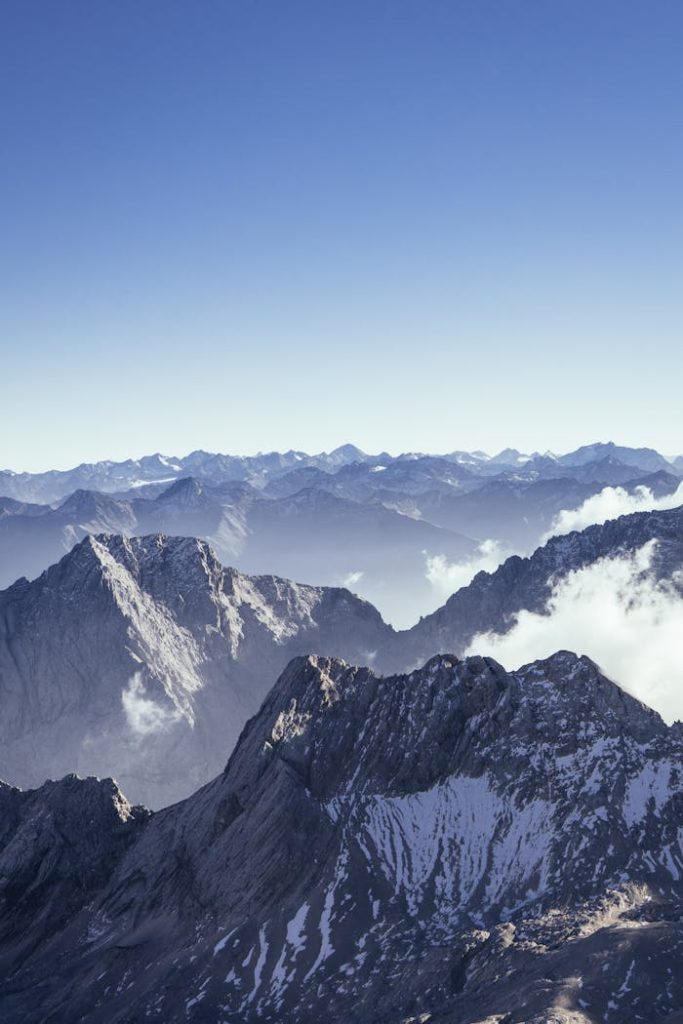A stunning aerial view of the snow-capped Alps in Ehrwald, Austria, showcasing rugged peaks and crisp winter skies.