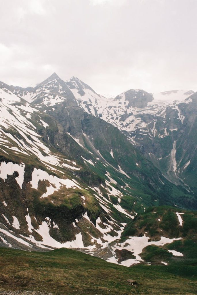 A breathtaking view of snow-capped mountains in the Austrian Alps during summer.