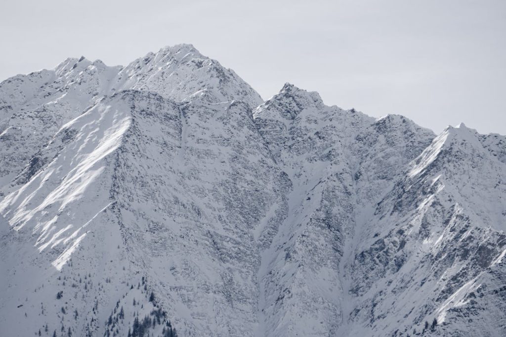 A breathtaking view of towering snow-covered mountain peaks under clear skies.
