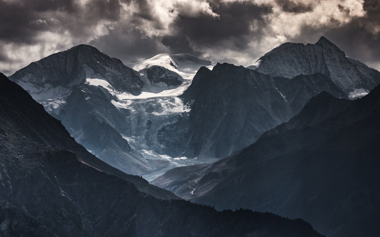 Breathtaking view of the dramatic Swiss Alps under moody clouds, showcasing natures raw beauty.