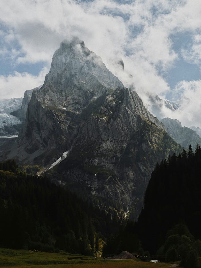 Majestic alpine peak shrouded in clouds in the landscape of Meiringen, Switzerland.