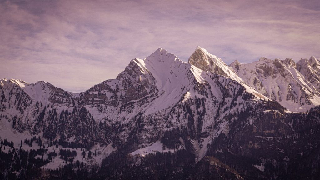 A stunning view of the snow-covered Swiss Alps mountains under a winter sky from Walenstadt, Switzerland.